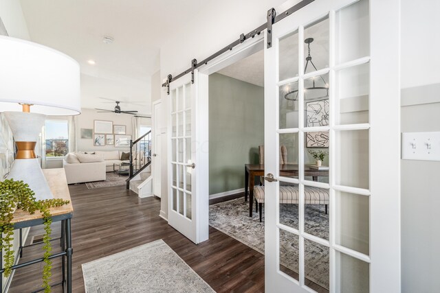 hallway featuring a barn door, french doors, baseboards, recessed lighting, and wood finished floors