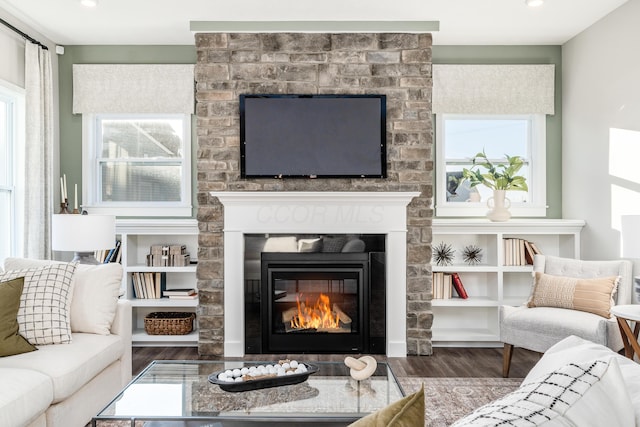 living room featuring recessed lighting, wood finished floors, and a large fireplace