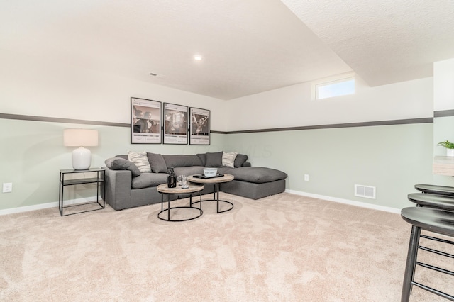 living room with carpet floors, visible vents, and baseboards