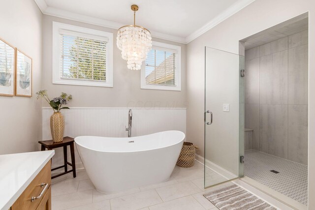 full bath with a shower stall, crown molding, vanity, an inviting chandelier, and a freestanding bath