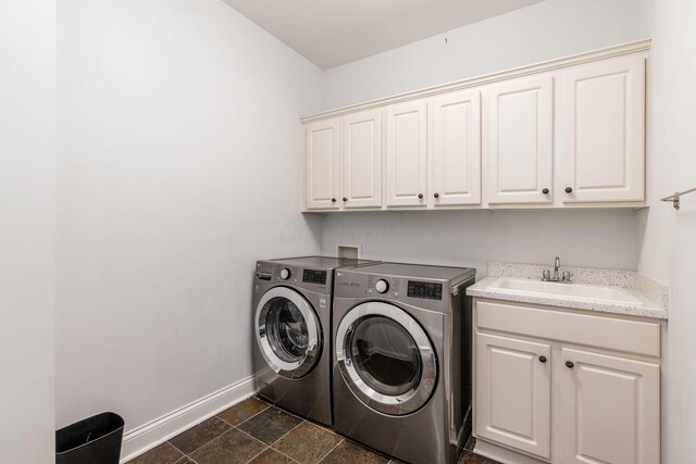 laundry room featuring washer and dryer, baseboards, a sink, and cabinet space