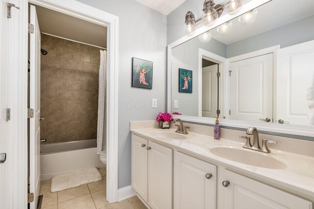 full bathroom featuring tile patterned floors, a sink, double vanity, and toilet