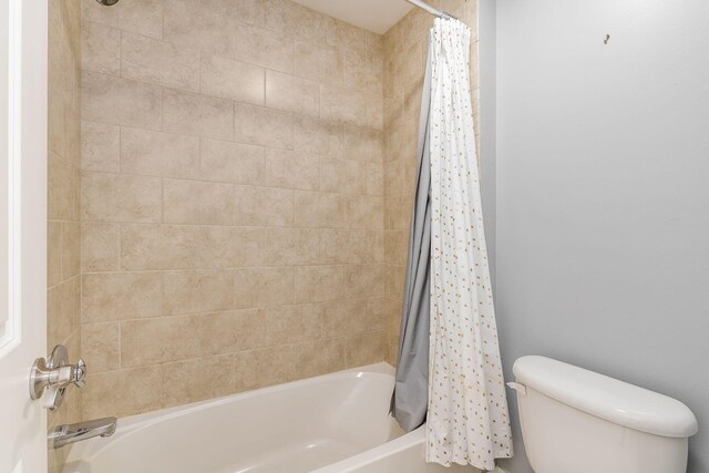 bathroom with toilet and shower / bathtub combination with curtain