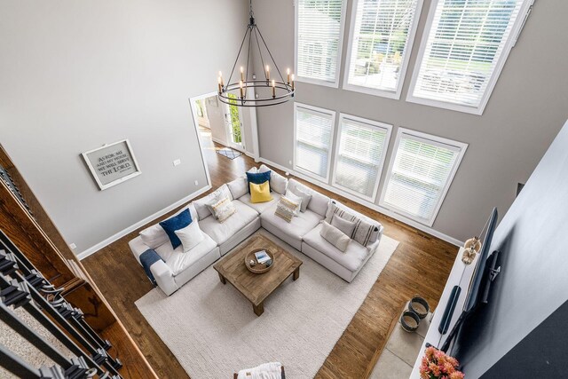 living room with a high ceiling, wood finished floors, and baseboards