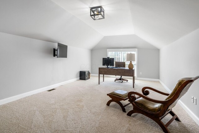 home office with baseboards, lofted ceiling, visible vents, and light colored carpet