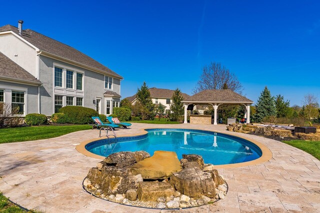 outdoor pool with a gazebo and a patio area