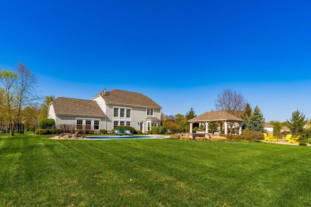 back of house featuring a lawn, a gazebo, and stucco siding