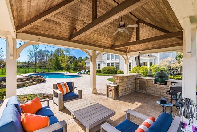 view of patio / terrace featuring a gazebo, an outdoor living space, a ceiling fan, grilling area, and exterior kitchen