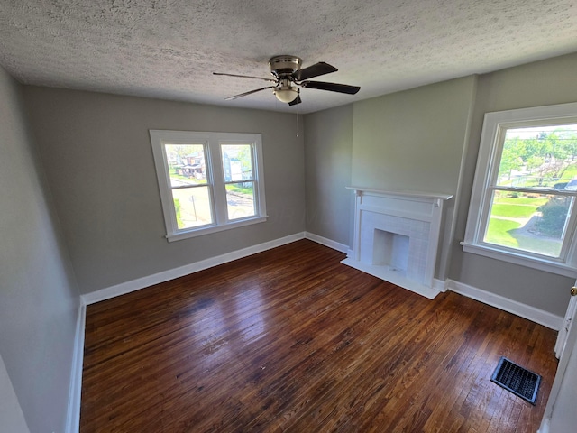 unfurnished living room with baseboards, visible vents, a healthy amount of sunlight, and wood-type flooring