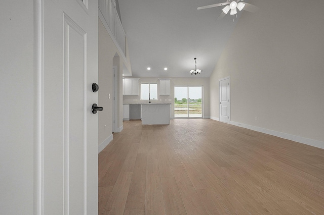 108 Cumberland Meadows Cir, Hebron, OH 43025 - unfurnished living room with ceiling fan, light wood-type flooring, baseboards, high vaulted ceiling, and arched walkways