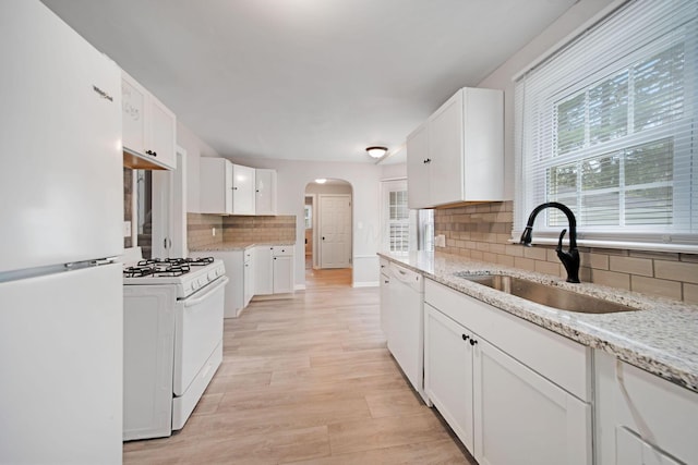 2575 Jordan Rd, Columbus, OH 43231 - kitchen with arched walkways, a sink, tasteful backsplash, white cabinetry, and white appliances