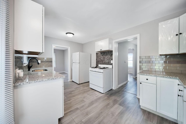 2575 Jordan Rd, Columbus, OH 43231 - kitchen with tasteful backsplash, light stone countertops, a sink, and white appliances