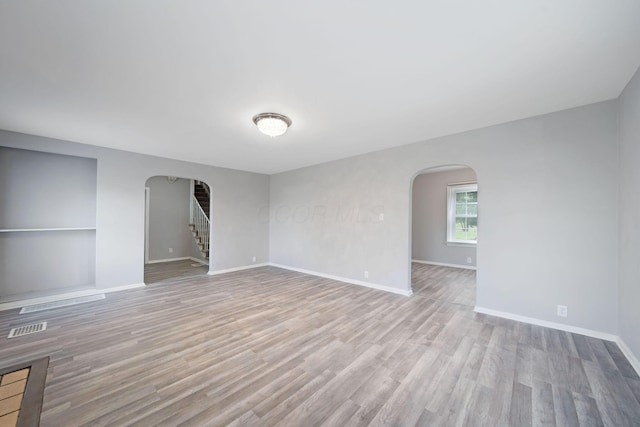 2575 Jordan Rd, Columbus, OH 43231 - spare room featuring arched walkways, wood finished floors, visible vents, and baseboards