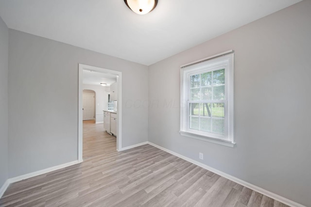 2575 Jordan Rd, Columbus, OH 43231 - empty room with arched walkways, light wood-style flooring, and baseboards