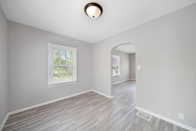 2575 Jordan Rd, Columbus, OH 43231 - spare room with arched walkways, a healthy amount of sunlight, wood finished floors, and visible vents