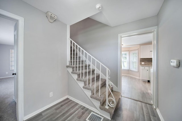 2575 Jordan Rd, Columbus, OH 43231 - stairs with baseboards, wood finished floors, and visible vents