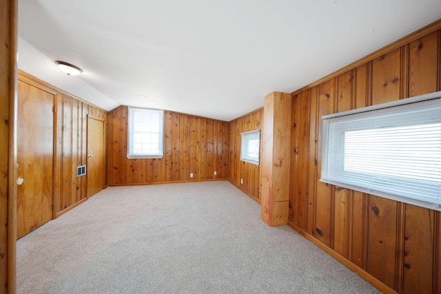 2575 Jordan Rd, Columbus, OH 43231 - empty room with vaulted ceiling, wood walls, light colored carpet, and a healthy amount of sunlight