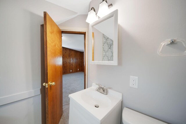 2575 Jordan Rd, Columbus, OH 43231 - bathroom with wood walls, toilet, vanity, and lofted ceiling