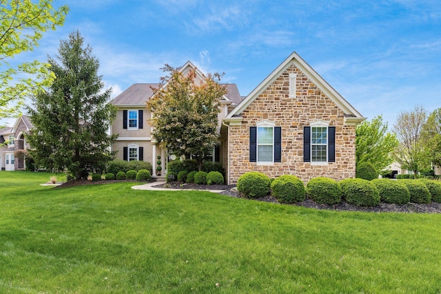 view of front facade featuring a front lawn and stone siding