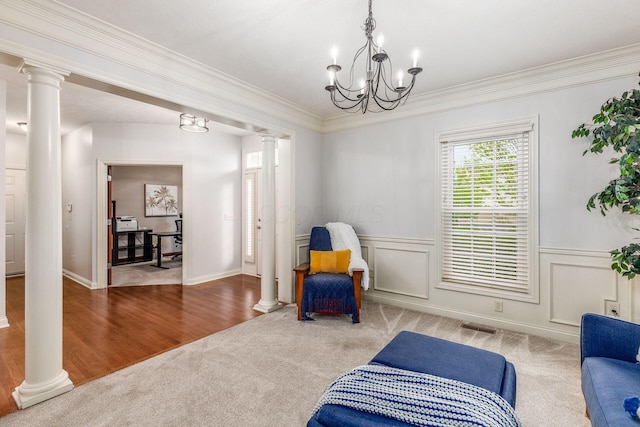 living area with visible vents, crown molding, carpet floors, a chandelier, and ornate columns