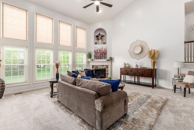 carpeted living room with a healthy amount of sunlight, high vaulted ceiling, ceiling fan, and visible vents