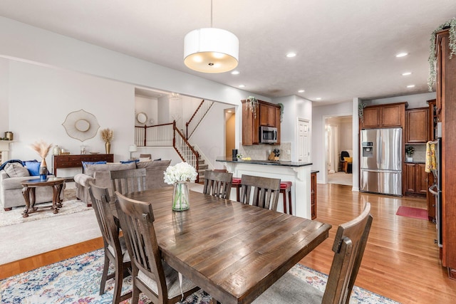dining room with stairway, recessed lighting, and light wood-style flooring