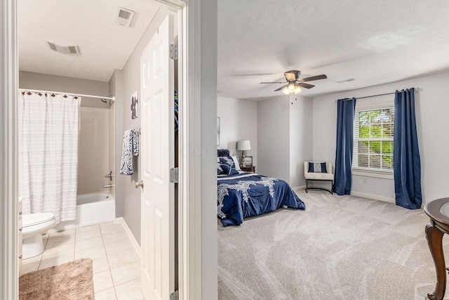 tiled bedroom with baseboards, a textured ceiling, ceiling fan, and visible vents