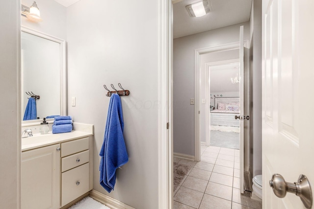 bathroom featuring baseboards, tile patterned flooring, and vanity