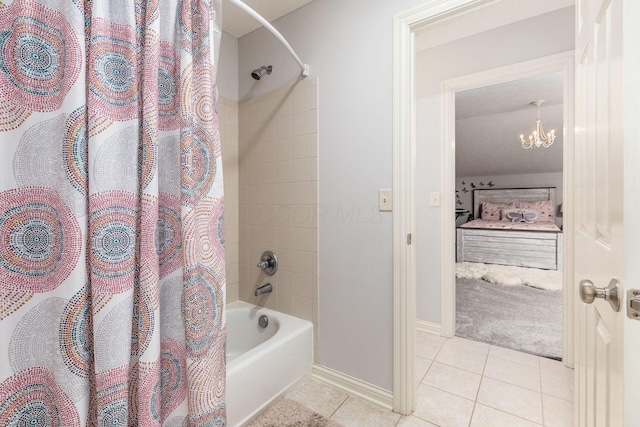 bathroom featuring tile patterned flooring, baseboards, shower / bath combo with shower curtain, and a notable chandelier