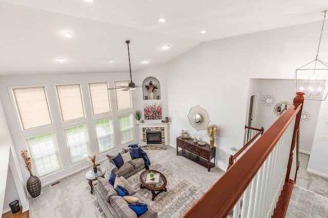 carpeted living room featuring lofted ceiling, a fireplace, baseboards, recessed lighting, and ceiling fan with notable chandelier