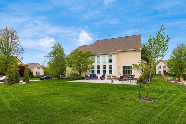 back of house with a lawn, a patio, an outdoor hangout area, and stucco siding