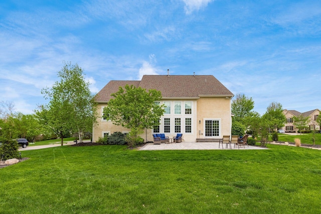 back of property featuring a lawn, a patio, and stucco siding