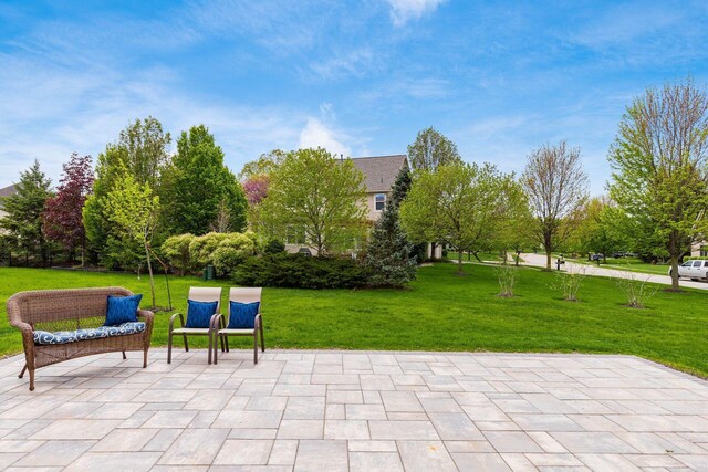 view of home's community featuring a lawn and a patio area