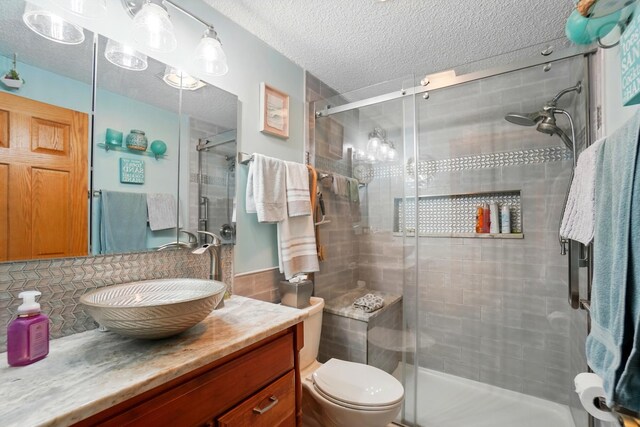 2680 Mellowbrook St, Columbus, OH 43232 - full bath with vanity, a shower stall, a textured ceiling, toilet, and tasteful backsplash