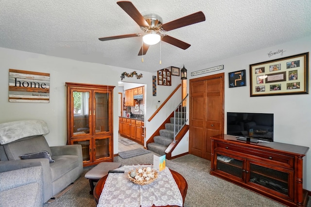 2680 Mellowbrook St, Columbus, OH 43232 - carpeted living area featuring a textured ceiling, ceiling fan, stairway, and a sink