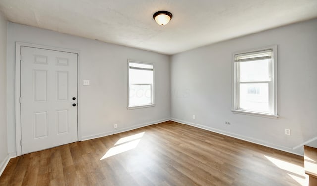 unfurnished room with baseboards and wood finished floors