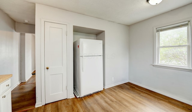 interior space with light wood finished floors and baseboards