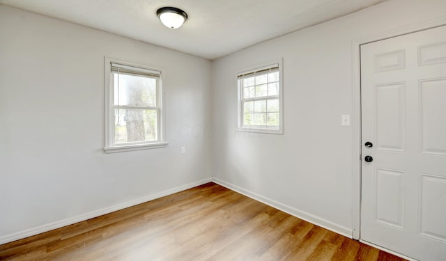 spare room with light wood finished floors and baseboards