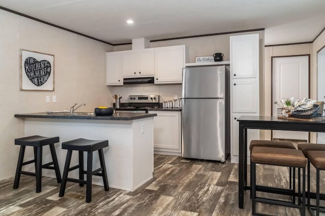 1330 Hanover Rd Unit 205, Delaware, OH 43015 - kitchen with stainless steel appliances, under cabinet range hood, a breakfast bar area, white cabinetry, and dark countertops