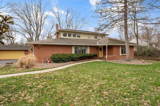 traditional home featuring a front yard, a chimney, and brick siding