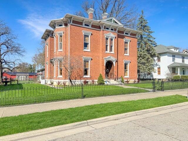 59 S Chillicothe St, South Charleston, OH 45368 - italianate house with a chimney, a front lawn, brick siding, and a fenced front yard