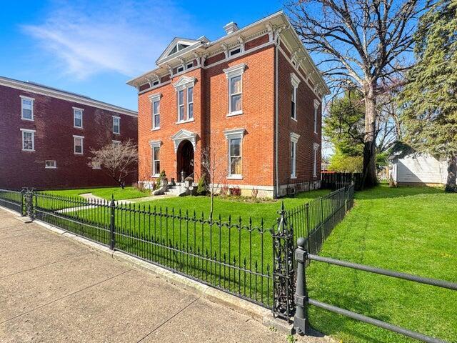 59 S Chillicothe St, South Charleston, OH 45368 - italianate-style house featuring brick siding, a front yard, and a fenced front yard