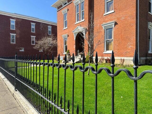 59 S Chillicothe St, South Charleston, OH 45368 - view of front of house featuring fence, a front lawn, and brick siding