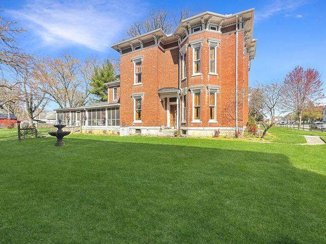 59 S Chillicothe St, South Charleston, OH 45368 - back of house with a lawn, a sunroom, and brick siding