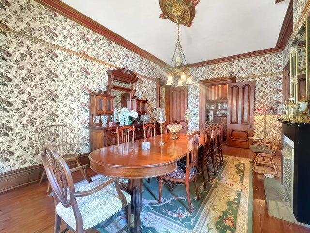 59 S Chillicothe St, South Charleston, OH 45368 - dining space with ornamental molding, wood finished floors, a chandelier, and wallpapered walls