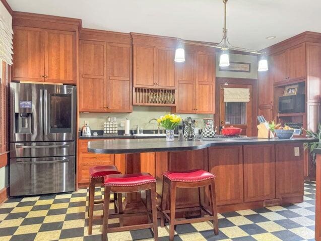 59 S Chillicothe St, South Charleston, OH 45368 - kitchen with a kitchen breakfast bar, light floors, dark countertops, pendant lighting, and stainless steel refrigerator with ice dispenser