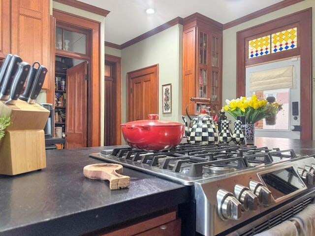59 S Chillicothe St, South Charleston, OH 45368 - kitchen with dark countertops, decorative backsplash, stainless steel gas range, glass insert cabinets, and ornamental molding