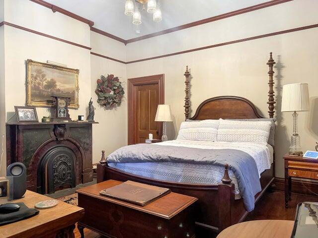59 S Chillicothe St, South Charleston, OH 45368 - bedroom featuring wood finished floors, a fireplace, and crown molding