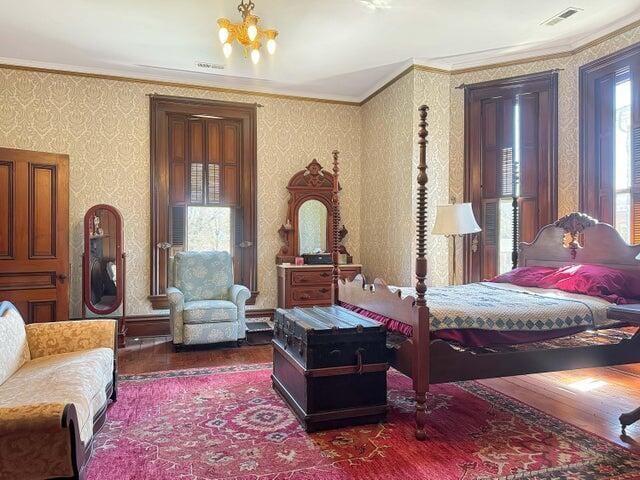 59 S Chillicothe St, South Charleston, OH 45368 - bedroom featuring wallpapered walls, wood finished floors, visible vents, and ornamental molding
