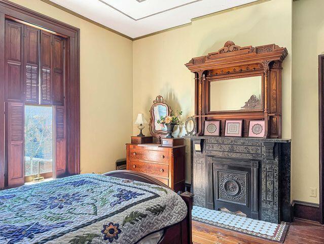 59 S Chillicothe St, South Charleston, OH 45368 - bedroom featuring access to outside, crown molding, wood finished floors, and a fireplace